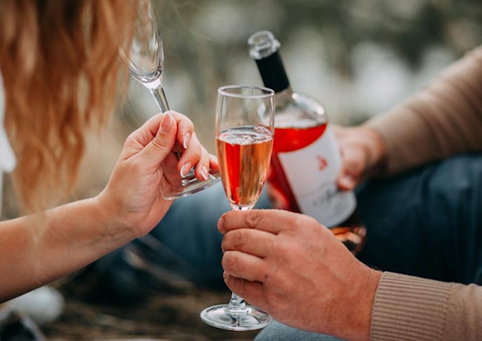 Couple holding glass flutes.